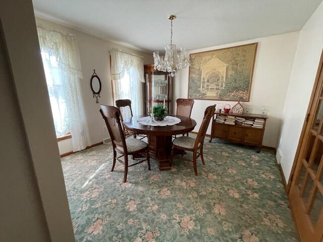 dining space with a notable chandelier and carpet floors