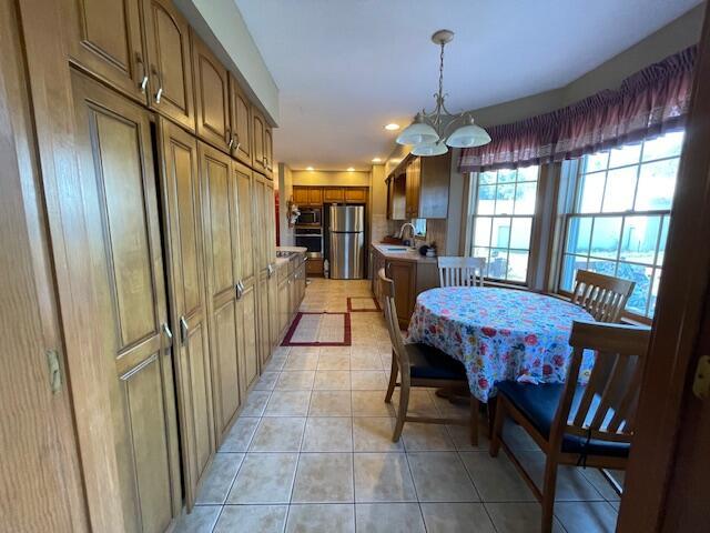 dining area featuring light tile patterned floors, a chandelier, and sink