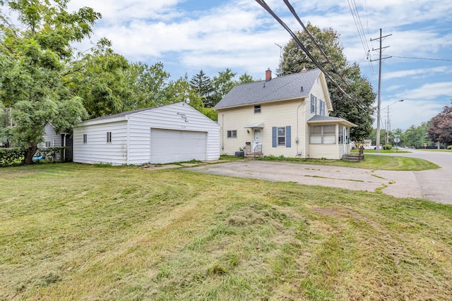 view of side of property featuring an outdoor structure, a garage, and a lawn