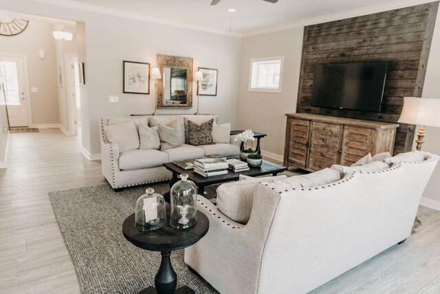 living room featuring crown molding, ceiling fan, and light hardwood / wood-style flooring