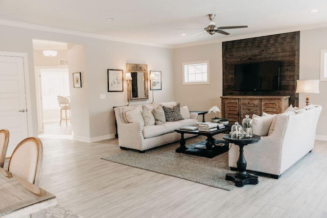 living room with ornamental molding, ceiling fan, and light wood-type flooring