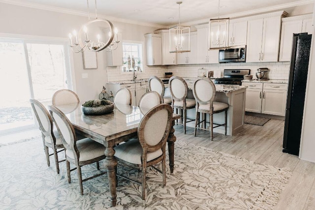 dining room featuring ornamental molding, light hardwood / wood-style floors, and sink