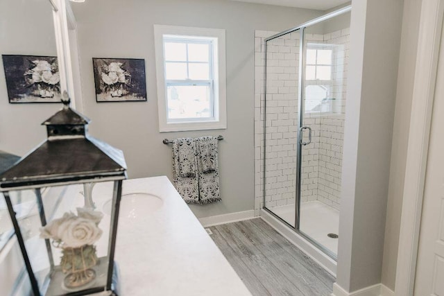 bathroom with a healthy amount of sunlight, hardwood / wood-style floors, and a shower with shower door