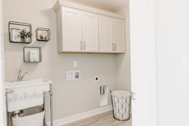 washroom with hookup for a washing machine, cabinets, hookup for an electric dryer, and light hardwood / wood-style flooring