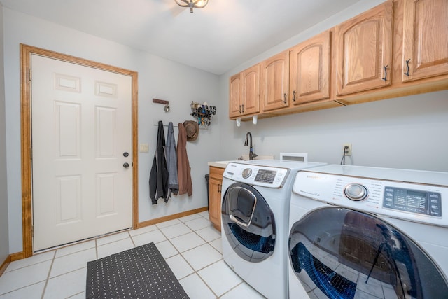 laundry room featuring light tile patterned flooring, cabinets, washing machine and clothes dryer, and sink