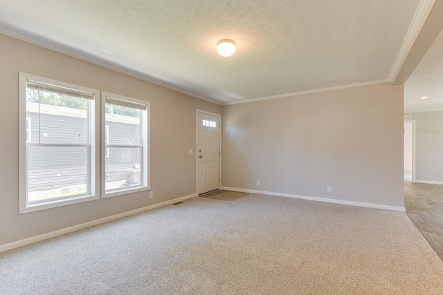 carpeted empty room with a textured ceiling and crown molding