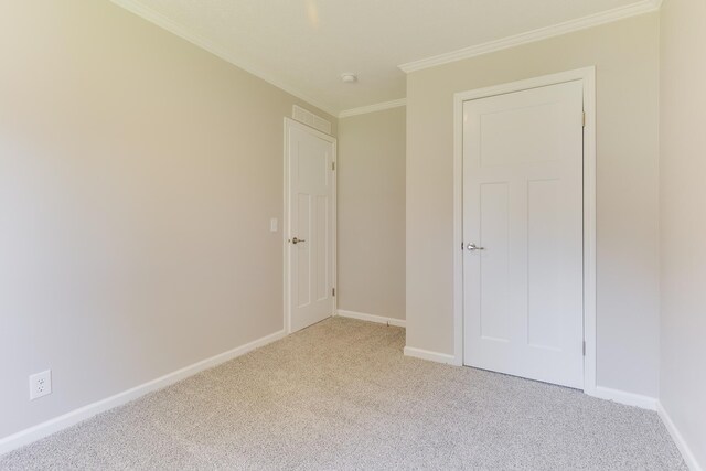 unfurnished bedroom with light carpet and crown molding