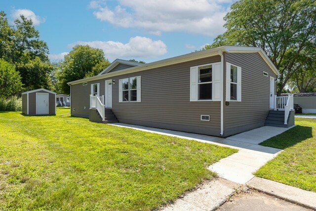 view of front of house featuring a front lawn and a shed