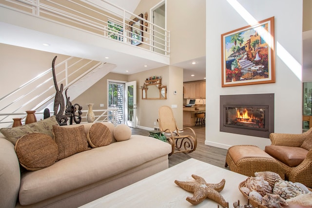 living room with a towering ceiling and hardwood / wood-style flooring