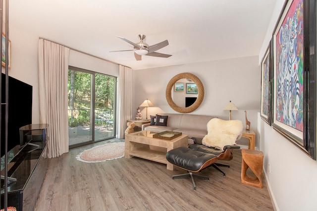 living room featuring light hardwood / wood-style flooring and ceiling fan