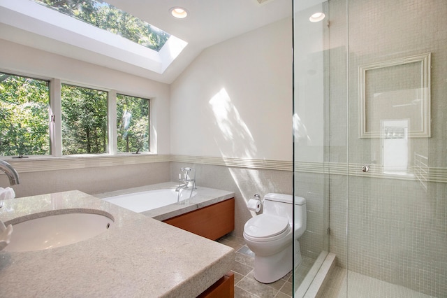 full bathroom featuring toilet, separate shower and tub, lofted ceiling with skylight, tile patterned floors, and vanity