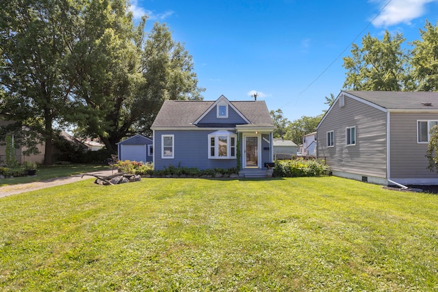 bungalow-style house with an outbuilding, a front yard, and a garage