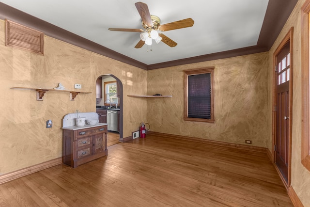 interior space featuring hardwood / wood-style floors, ceiling fan, crown molding, and sink