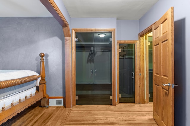 bedroom with light hardwood / wood-style flooring and a closet