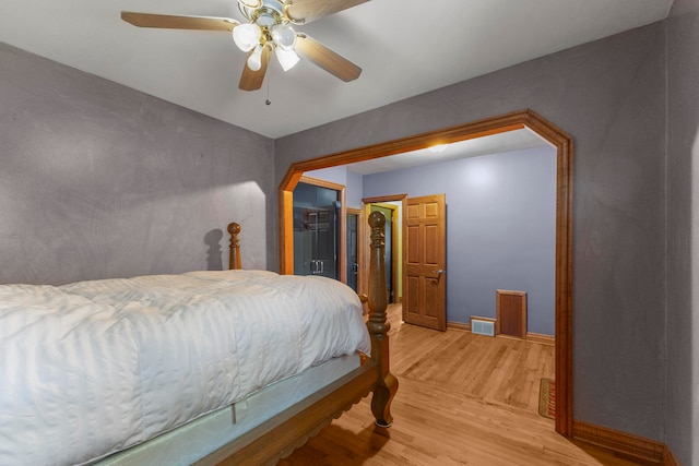 bedroom with a closet, ceiling fan, hardwood / wood-style floors, and a spacious closet