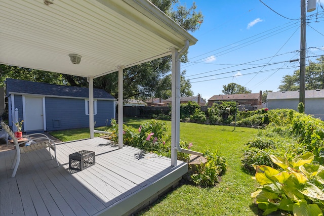 wooden deck with a yard and a storage unit