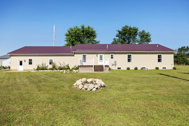 rear view of property with a wooden deck and a lawn