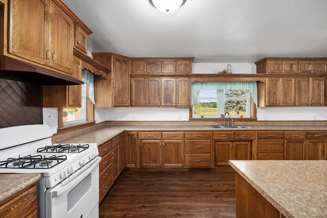 kitchen with a textured ceiling, dark wood-type flooring, sink, and white range with gas cooktop