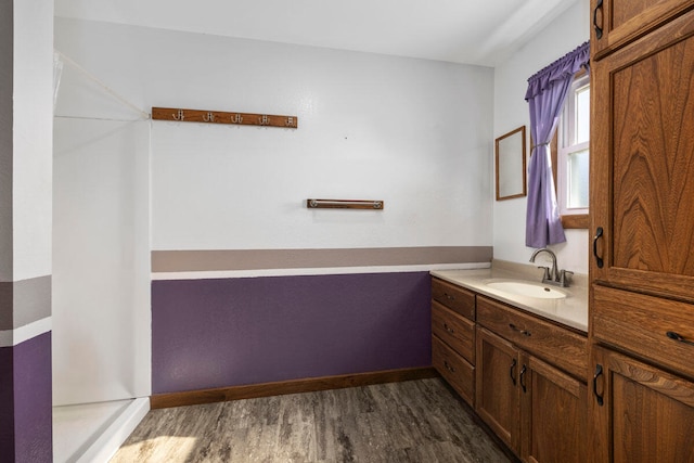 bathroom with wood-type flooring, walk in shower, and vanity