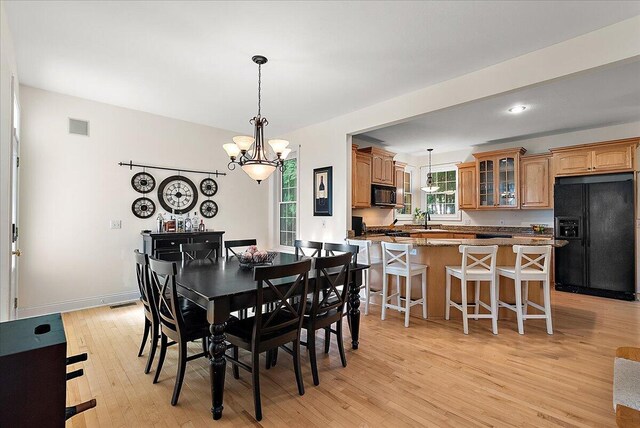 dining room featuring a chandelier, light hardwood / wood-style floors, and sink