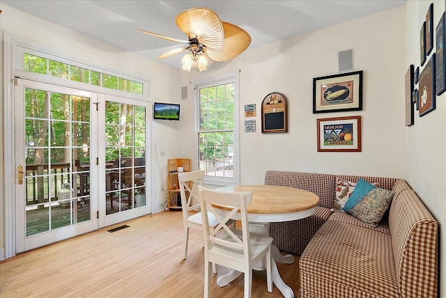 dining space with light wood-type flooring and ceiling fan