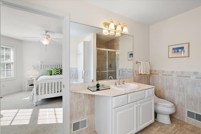 bathroom with walk in shower, toilet, tile walls, ceiling fan, and vanity