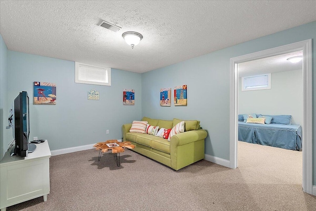 carpeted living room featuring a textured ceiling