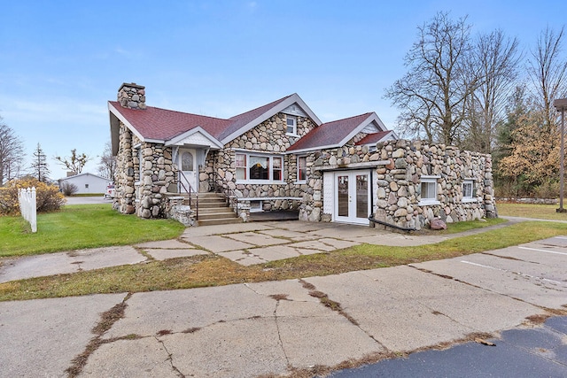 view of front of home with french doors and a front yard