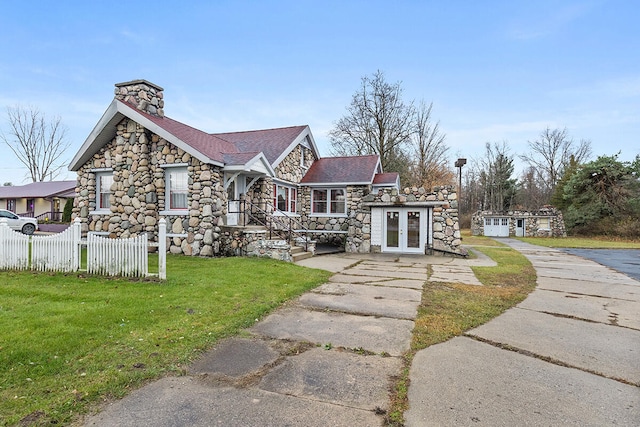 view of front facade featuring a front yard and french doors