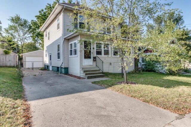 view of front of property with a front yard, a garage, and an outdoor structure