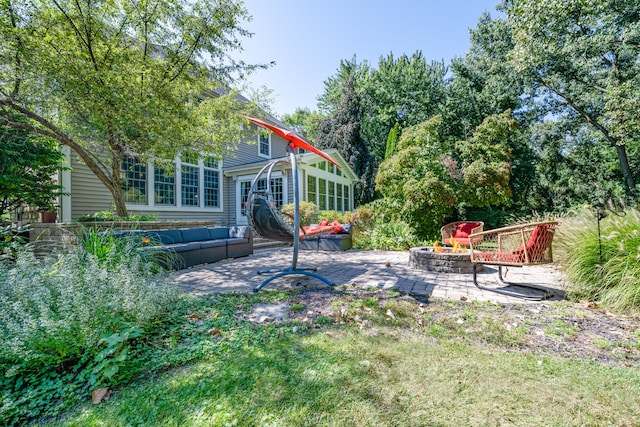 view of yard featuring an outdoor living space with a fire pit and a patio