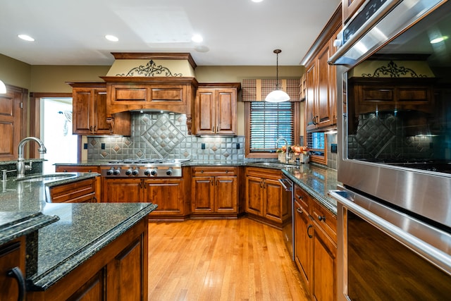 kitchen featuring a wealth of natural light, light hardwood / wood-style flooring, stainless steel appliances, and sink