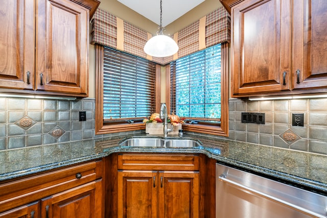 kitchen featuring dark stone counters, pendant lighting, backsplash, sink, and stainless steel dishwasher