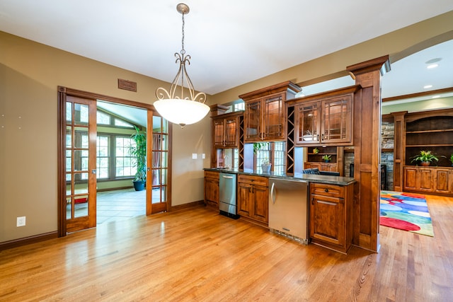 kitchen featuring hanging light fixtures, french doors, light hardwood / wood-style flooring, stainless steel appliances, and dark stone counters