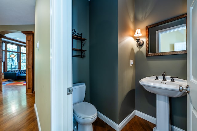 bathroom featuring wood-type flooring, toilet, and ornate columns