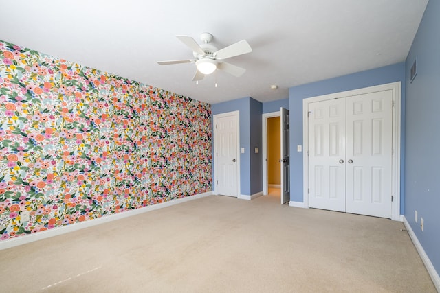 unfurnished bedroom with a closet, ceiling fan, and light carpet