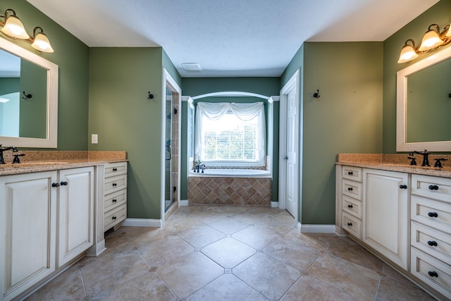 bathroom featuring tile patterned flooring, vanity, plus walk in shower, and a textured ceiling