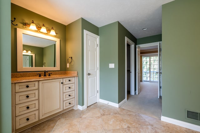 bathroom featuring tile patterned flooring, vanity, and a textured ceiling