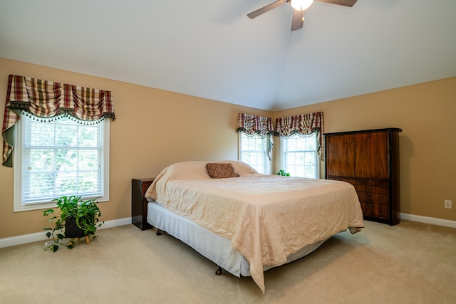 bedroom featuring light colored carpet, vaulted ceiling, and ceiling fan