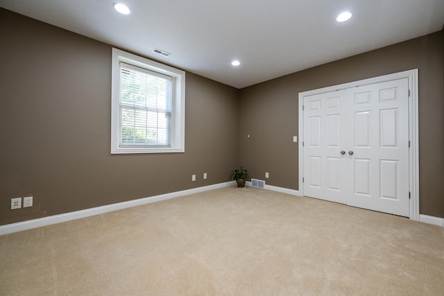 unfurnished room featuring light colored carpet