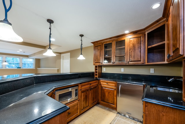 kitchen with appliances with stainless steel finishes, light tile patterned floors, decorative light fixtures, and sink