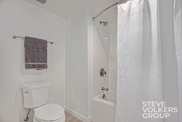 bathroom featuring toilet, shower / tub combo, and hardwood / wood-style floors