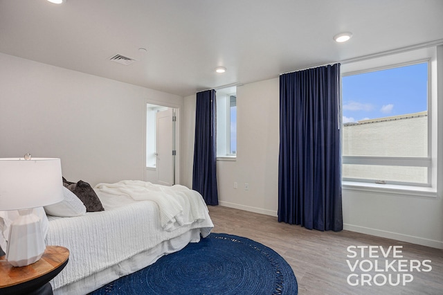 bedroom featuring multiple windows and light hardwood / wood-style floors