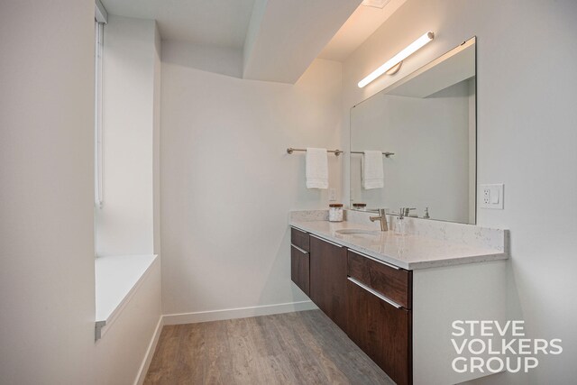 bathroom with hardwood / wood-style floors, a bathtub, and vanity