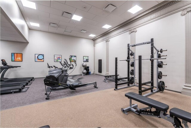 exercise room featuring a paneled ceiling and carpet flooring