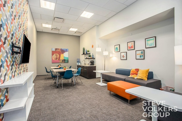 recreation room featuring carpet floors and a drop ceiling