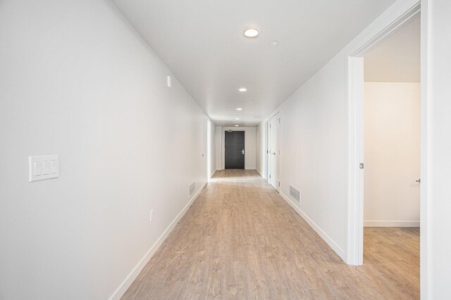 corridor with light hardwood / wood-style floors