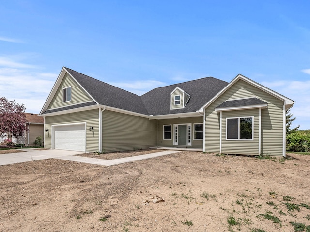 view of front of property featuring a garage, roof with shingles, and concrete driveway