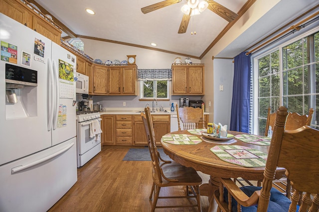 kitchen with light countertops, lofted ceiling, ornamental molding, light wood-style flooring, and white appliances