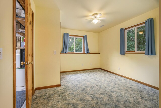 carpeted spare room with ceiling fan